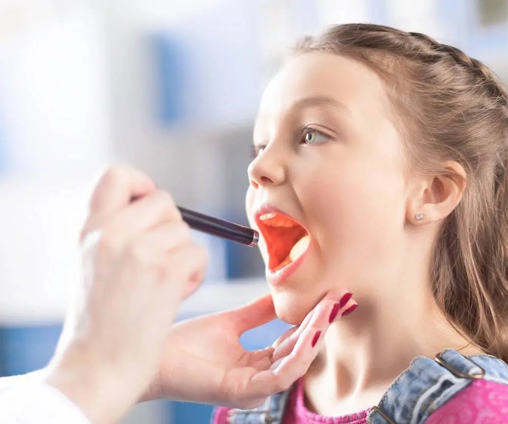 A young girl is being examined by an adult.